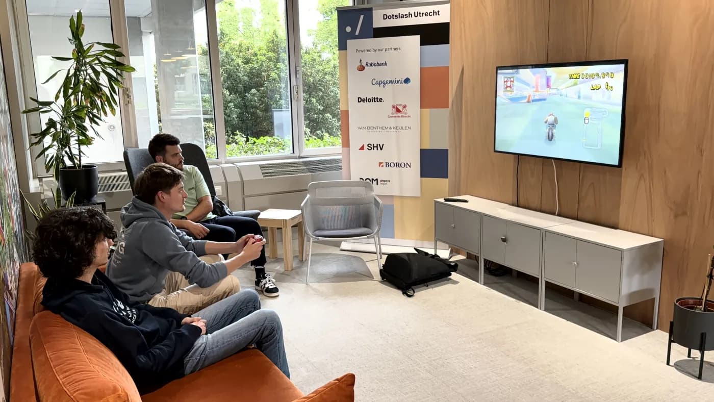 Drie bezoekers spelen Mario Kart Wii in de lobby van Dotslash Utrecht